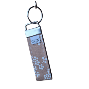 Beige Wristlet with white vein floral print with a silver clasp and keyring