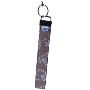 Beige Wristlet with white vein floral print with a silver clasp and keyring