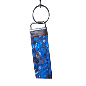 Wristlet with a dark blue and black floral abstract pattern and silver clasp and keyring