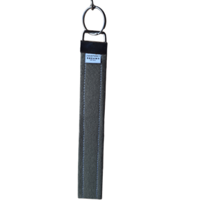 Fabric wristlet keychain strap in a solid dark green material attached to a silver metal key ring.