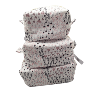 Three separate cosmetic pouches in a purple floral bud pattern, stacked vertically from largest to smallest.