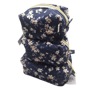 Three-tier travel pouch set in a light blue and grey botanical leaf pattern, stacked vertically.